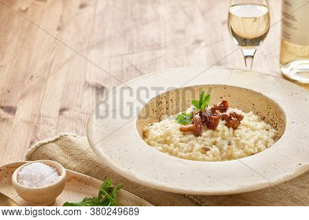 Risoto With Chanterelle Mushrooms In Large Plate. Traditional Italian Dish.