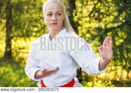 Young Woman Dressed In Kimono Practicing Her Karate Moves In Park - Red Belt