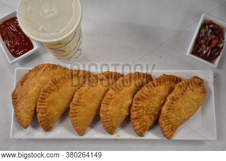 Crispy Empenadas On A Long White Plate