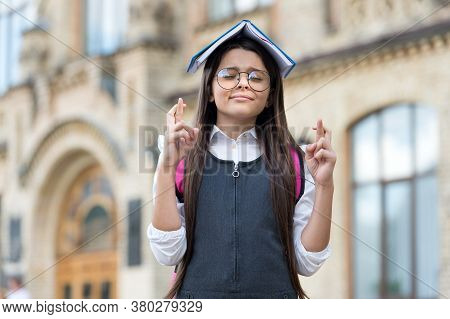 Crossing Fingers For Luck. Little Geek Make Wish Outdoors. Small Child Hold Book On Head. Knowledge 
