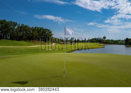 Golf Course With Bunker, Lake And Green. Golf Course With A Rich Green Turf Beautiful Scenery.