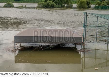 Top Of Benches Submerged By Flood Water At Baseball Diamond In Riverside Park After Torrential Monso