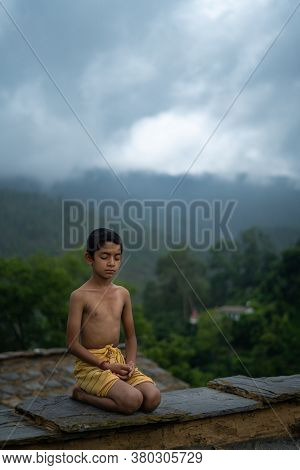 A Young Indian Cute Kid Doing Yoga In The Mountains,wearing A Dhoti