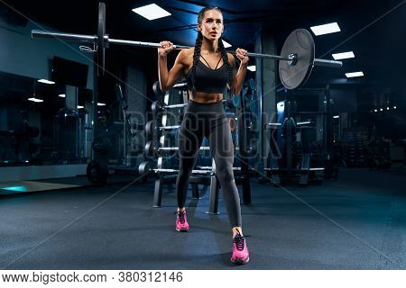 Side View Of Brunette Female Bodybuilder With Long Braids Doing Lunges Using Barbell. Srtong Woman W
