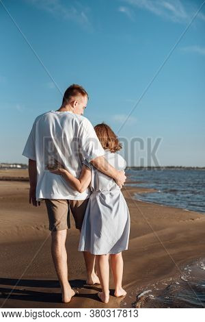 Couple In Love On The Beach.young Man And Woman Walking On Seashore And Laughing.