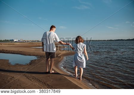 Couple In Love On The Beach.young Man And Woman Walking On Seashore And Laughing.