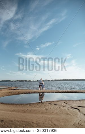 Couple In Love On The Beach.young Man And Woman Walking On Seashore And Laughing.