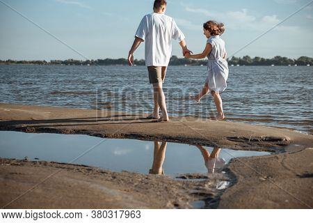 Couple In Love On The Beach.young Man And Woman Walking On Seashore And Laughing.