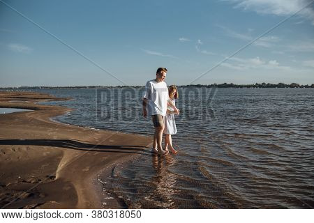 Couple In Love On The Beach.young Man And Woman Walking On Seashore And Laughing.