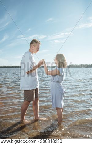 Couple In Love On The Beach.young Man And Woman Walking On Seashore And Laughing.