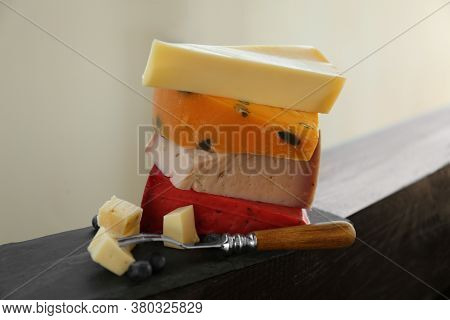 Different Types Of Delicious Cheeses And Fork On Slate Plate, Closeup