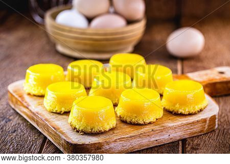 Egg Yolk Candy, Called Quindim In Brazil, And Portugal In Brisa-do-lis. Sweet Dessert On Rustic Wood