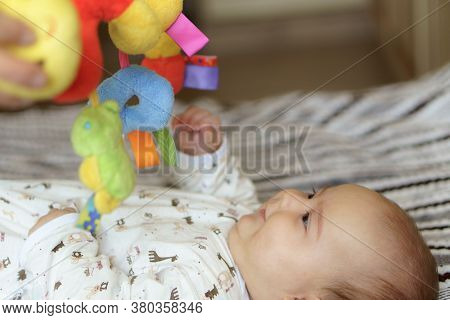 Cute Baby Girl On Colorful Playmat And Gym, Playing With Hanging Rattle Toys. Kids Activity And Play
