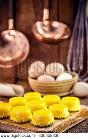 Egg Yolk Candy, Called Quindim In Brazil, And Portugal In Brisa-do-lis. Sweet Dessert On Rustic Wood