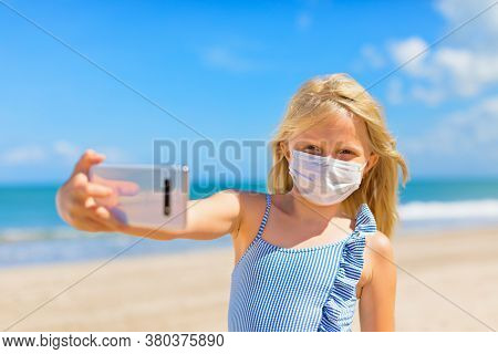 Funny Kids Taking Selfie Photo By Smartphone On Tropical Sea Beach. New Rules To Wear Cloth Face Cov