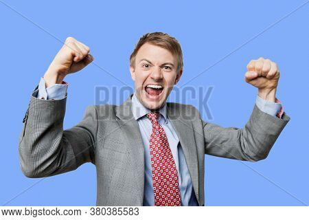 Celebrating businessman punching the air in celebration