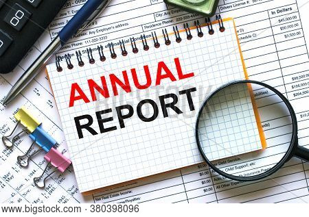 Text Annual Report On Notepad With Calculator, Clips, Pen On Financial Report