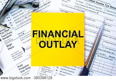 Text Financial Outlay On Note Paper With The U.s Irs 1040 Form,pen And Glasses