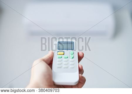 Air Condition Remote Control. Hand With Room Conditioner Remote Control. Air Temperature Switch For 