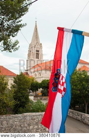 Closeup Of The Croatian Flag Waving In The Wind With The Church In The Village Of Selca, Croatia In 