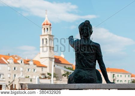 Statue Of A Little Girl Pointing At The Belltower In The Coastal Small Town Of Sutivan On The Island