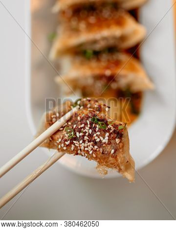 Eating Cooked Japanese Gedza Dumplings With Soy Sauce