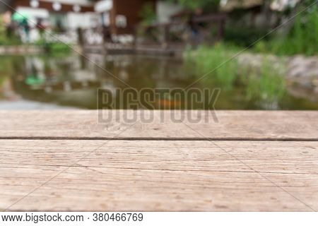Table Top Or Shelf Against Water Background. Montage With Focus To The Shalf In The Foreground And P