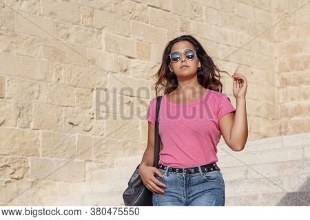 Young Women Wearing T-shirt And Jeans Going Down The  Stairs