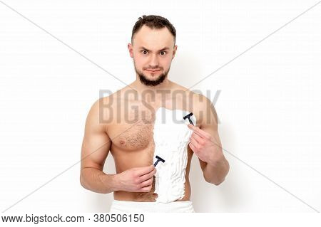 Young Caucasian Man With Beard Holds Razor Shaves His Chest With White Shaving Foam On White Backgro
