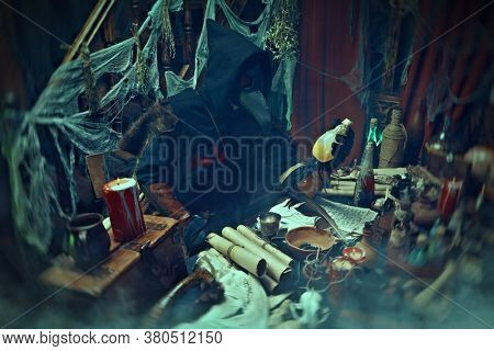 The plague doctor is working at his desk, inventing a cure for bubonic plague. The atmosphere of mysticism. Historical reenactment. Halloween. 