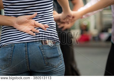 The Girl Makes Her Left Finger Cross Back, While Using The Right Hand To Do Fist Bump With Her Frien