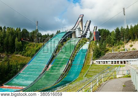 Lahti, Finland - 4 August 2020: Lahti Sports Centre With Three Ski Jump Towers. Sportsman Is Jumping