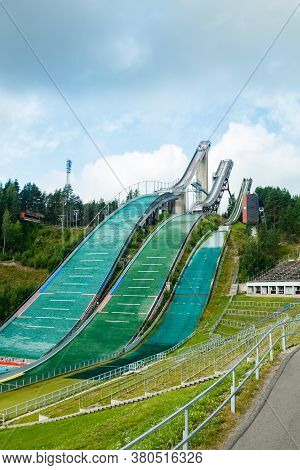 Lahti, Finland - 4 August 2020: Lahti Sports Centre With Three Ski Jump Towers. Sportsman Is Jumping