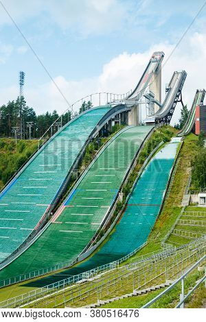 Lahti, Finland - 4 August 2020: Lahti Sports Centre With Three Ski Jump Towers. Sportsman Is Jumping