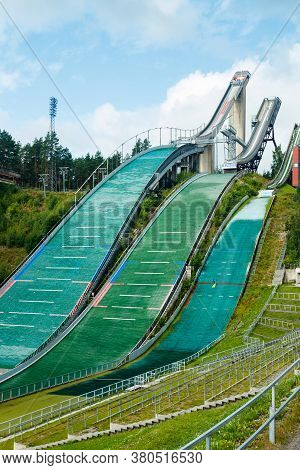 Lahti, Finland - 4 August 2020: Lahti Sports Centre With Three Ski Jump Towers. Sportsman Is Jumping