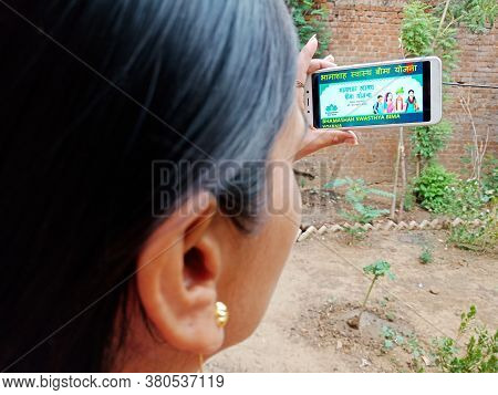 District Katni, India - 28 May 2020: An Indian Lady Holding Smart Phone With Displaying Bhamashah Sw