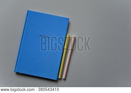 Blue Notebook With Two Pens On A Blue Paper Background. Top View. Close-up. Flat Lay.