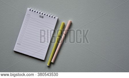 Notepad With Two Pens On A Blue Paper Background. Top View. Close-up. Flat Lay.
