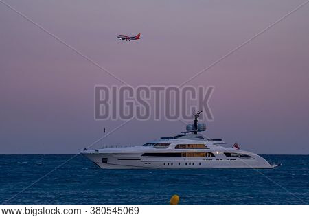 Cagnes-sur-mer, France 22.07.2020 Modern Luxury Yacht On The Sea And Flying Passenger Plane Later Ev