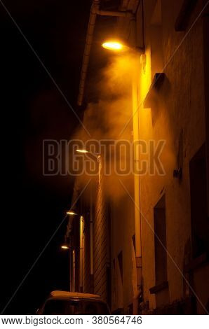 Illuminated street lights in the fog at night. Sabinanigo. Huesca. Aragon. Spain.