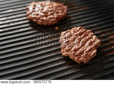 Beef Burger Patties On Griddle Pan Cooking. Copy Space For Design Mockup