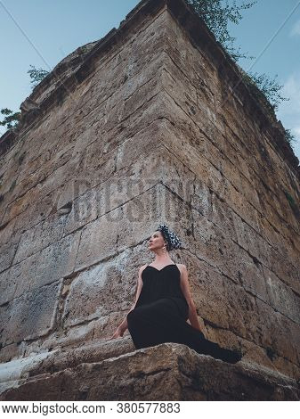 Close-up View Of Beautiful Young, Attractive Muslim Woman In Long Black Dress Standing On The Corner