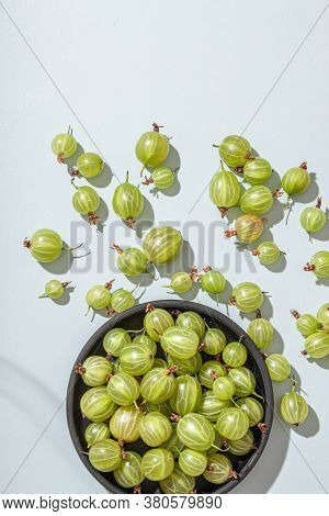 Ripe Green Gooseberry Berry In Plate Bowl. Green Gooseberry On Light Blue Background. Top View