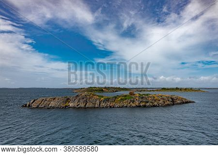 The Sea Port Sign For Passing Ships Stands On A Rocky Island In Cold Scandinavian Waters.