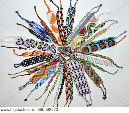 Many Woven Handmade Friendship Bracelets With Bright Colorful Pattern Made Of Embroidery Thread On W
