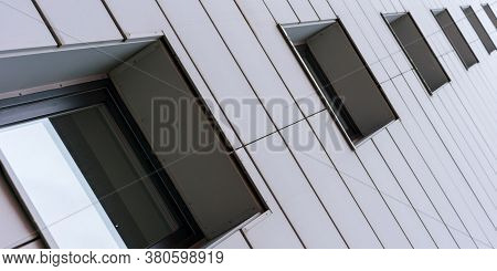 City Building Windows Of Brown Colour Located In Wall With White Blocks Under Bright Summer Unlight 