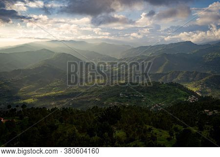 A Beautiful Landscape Of Mountain Range From Top Of A Cliff, With Scenic Beautiful Clouds Over Them.