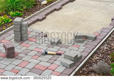 Worker Laying Paving Stones. Stone Pavement, Construction Worker Laying Cobblestone Rocks On Sand.