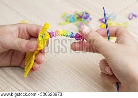 Rubber Band Weaving. Knitting Rubber Bands With Loom Knit. Hands Of Girl Weaving Wristband Of Rubber