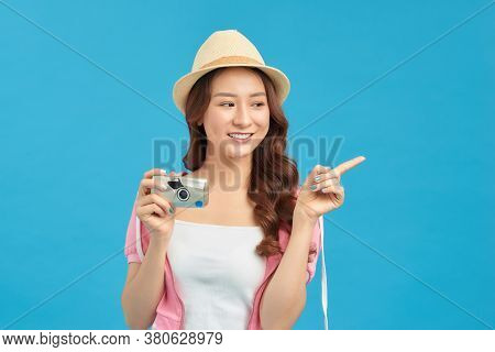 Attractive Energetic Asian Woman Happily Holding Cemara Isolated On Blue Studio Background